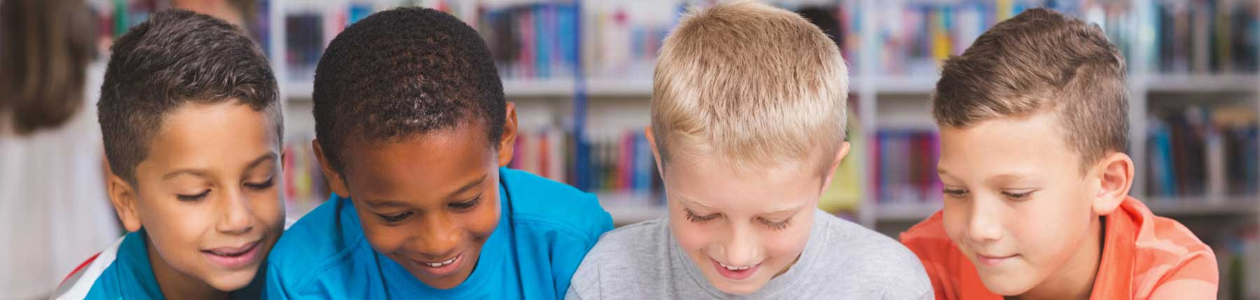 Unbound and Rooted About Us image four young boys looking at book